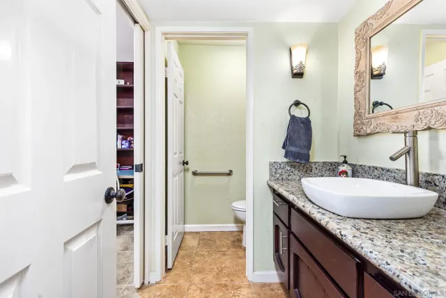 a bathroom with a granite countertop sink and a mirror