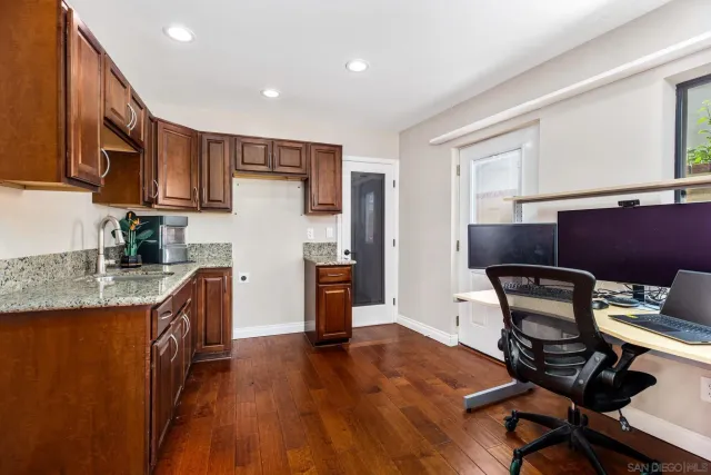 a kitchen with granite countertop a sink appliances and cabinets