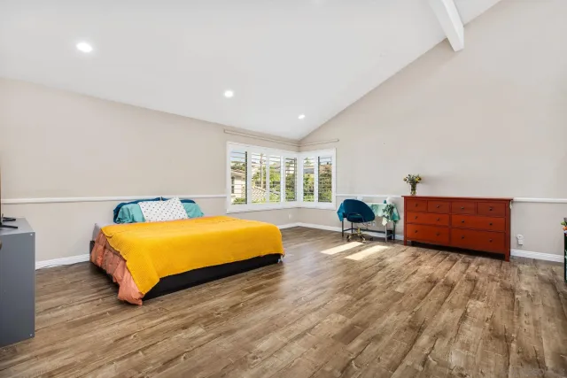 a bedroom with furniture and a large window