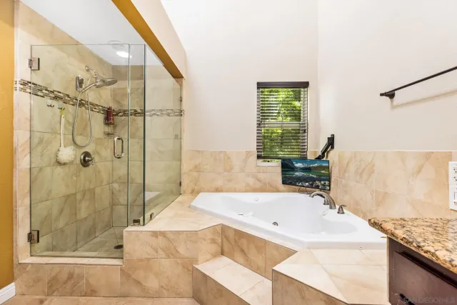 a bathroom with a granite countertop tub sink and shower