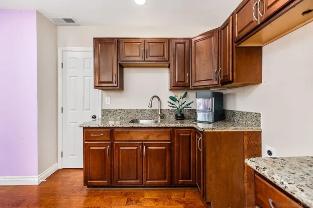 a kitchen with granite countertop a sink stove and cabinets