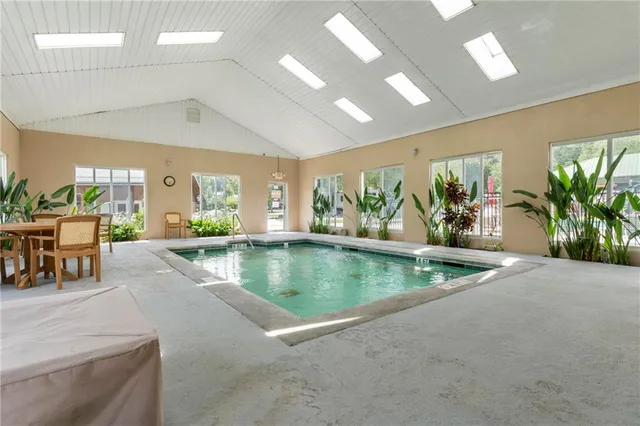 a view of swimming pool with a yard and palm trees