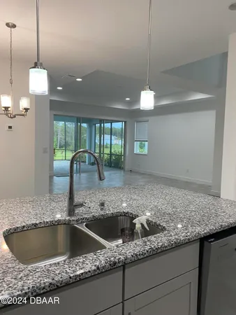 a kitchen with a sink a counter and wooden floor