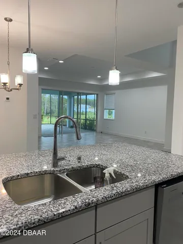 a kitchen with a sink a counter and wooden floor