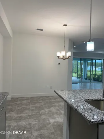 a view of a kitchen with granite countertop cabinets and a chandelier