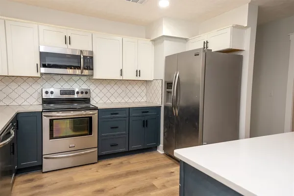 a kitchen with stainless steel appliances granite countertop a refrigerator stove and microwave