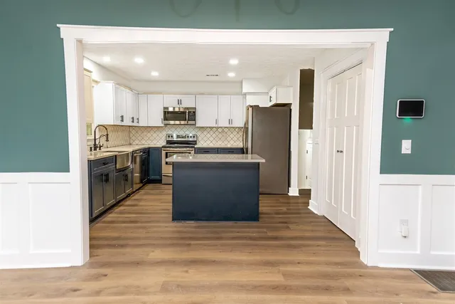 a kitchen with stainless steel appliances granite countertop a refrigerator and a stove top oven