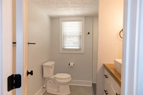 a bathroom with a toilet a sink and a window