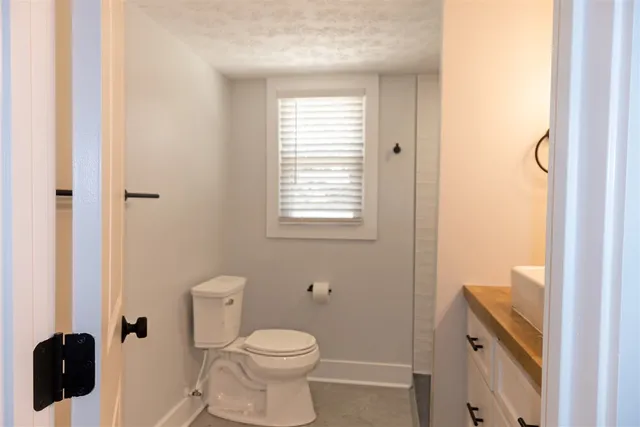 a bathroom with a toilet a sink and a window