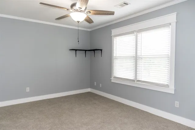 an empty room with a window and a fan