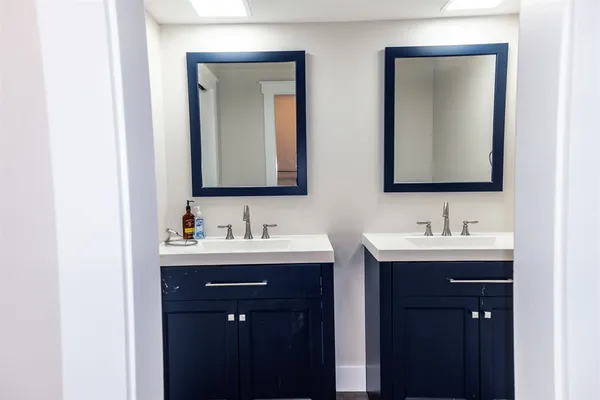 a bathroom with double sink and a mirror
