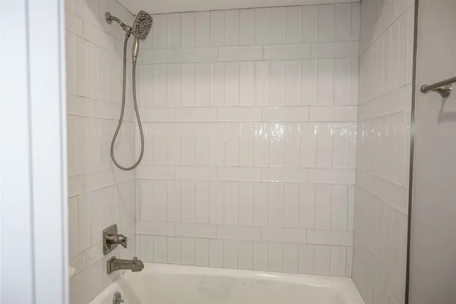 a bathroom with a bath tub with a shower