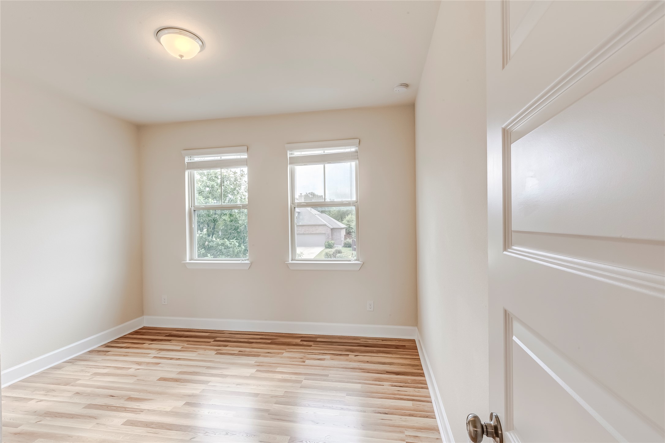 345 Fort Cobb Way Georgetown, TX 78628 - Photo 27 of 38 Warm wood flooring and classic sash windows define this inviting, empty bedroom space.