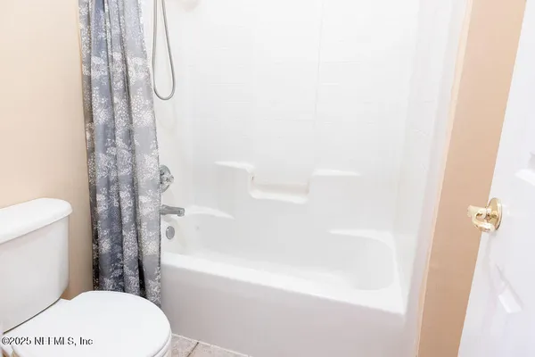 a bathroom with a shower a toilet and a shower