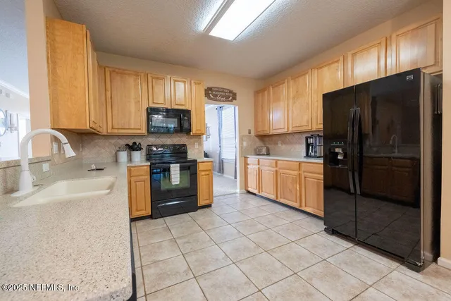 a kitchen with granite countertop a refrigerator and a sink