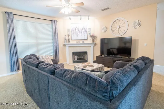 a living room with furniture a flat screen tv and a fireplace