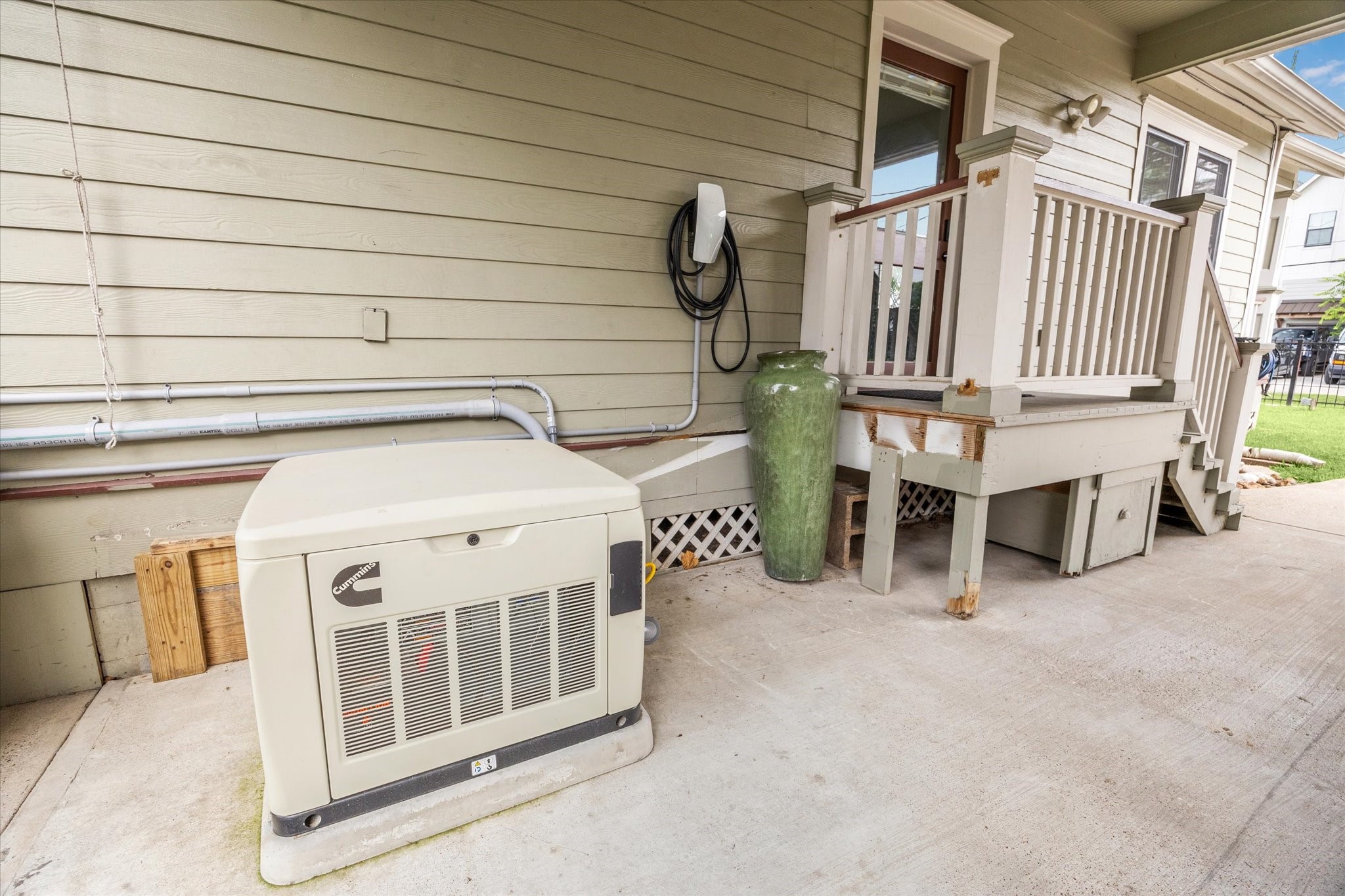 1321 West 21st Street Houston, TX 77008 - Photo 28 of 31 This home is equipped with a Cummins whole-home generator, providing reliable backup power during outages. A Tesla wall charger is conveniently installed, offering added value for electric vehicle owners. The setup is neatly positioned with easy access from the home, reflecting thoughtful functionality and preparedness. These features enhance both efficiency and peace of mind for everyday living.