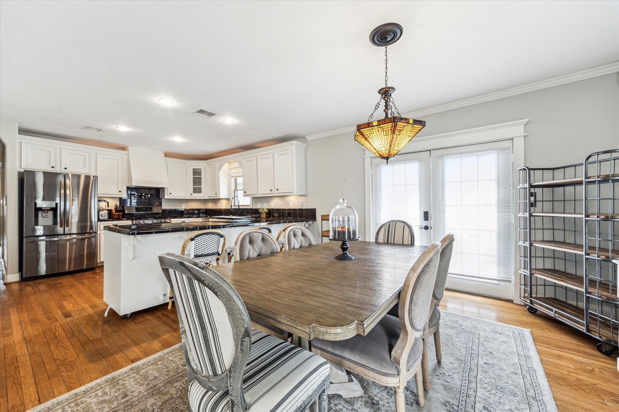 1321 West 21st Street Houston, TX 77008 - Photo 10 of 31 Dining room offers an open layout that seemingly connects the kitchen and living room space. Light fixture adds warmth and character. French doors open up to side deck that allows extended entertainment area.