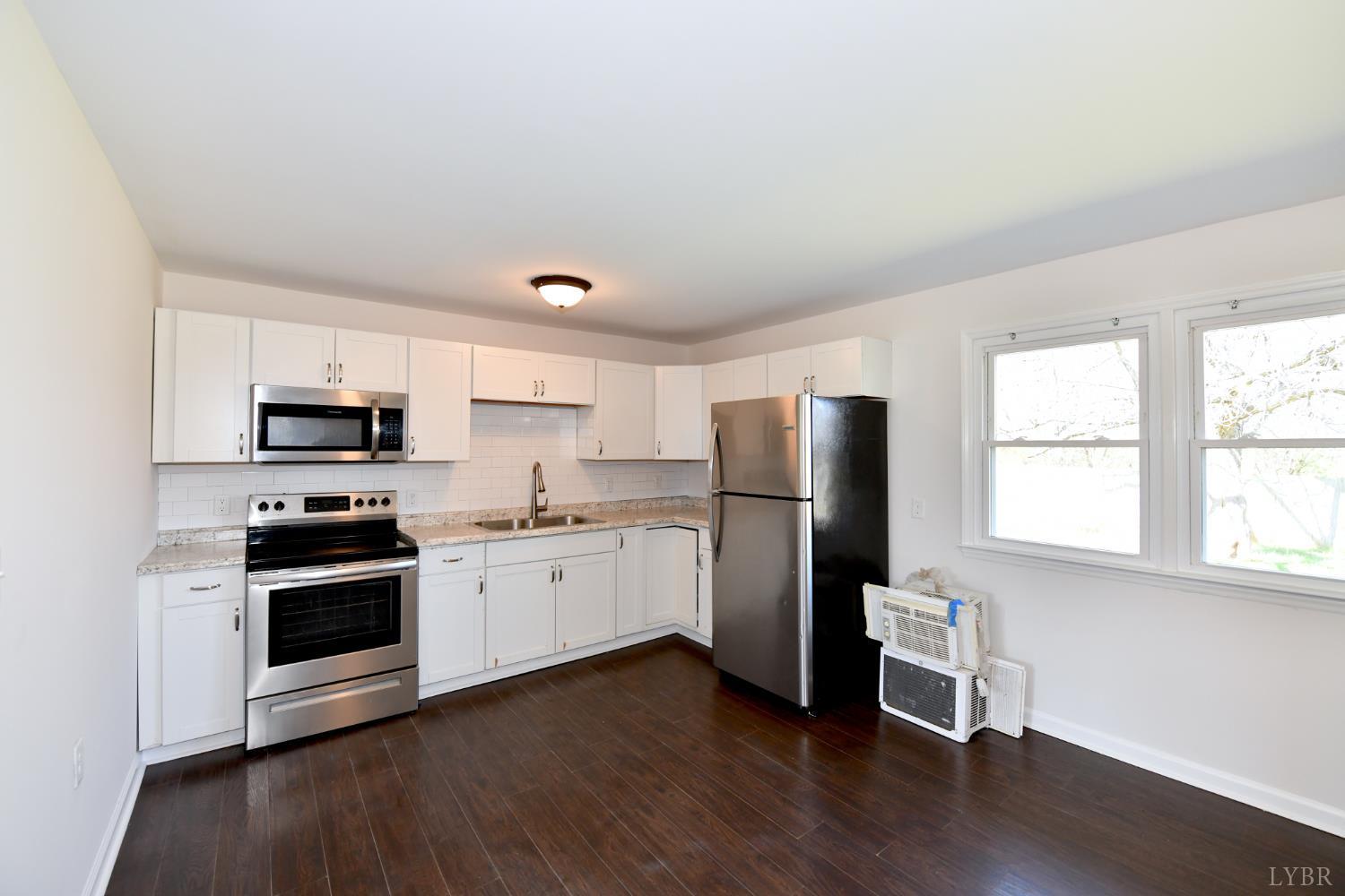 5763 3 Creeks Road Gladys, VA 24554 - Photo 11 of 25 a kitchen with a refrigerator stove and wooden floor