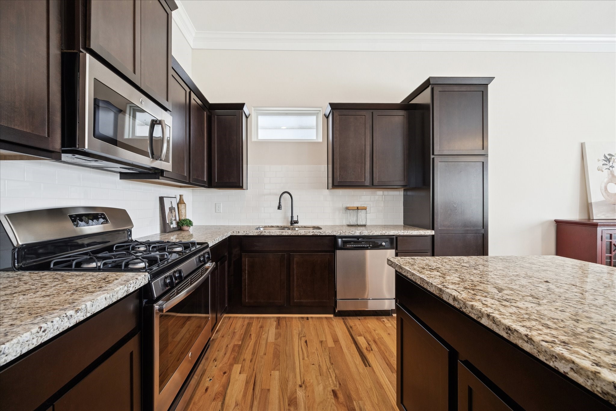 1546 West 23rd Street Houston, TX 77008 - Photo 8 of 20 a kitchen with stainless steel appliances granite countertop a stove top oven a sink dishwasher and wooden cabinets with wooden floor