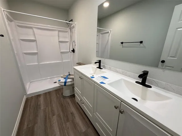 a bathroom with a sink a toilet and shower