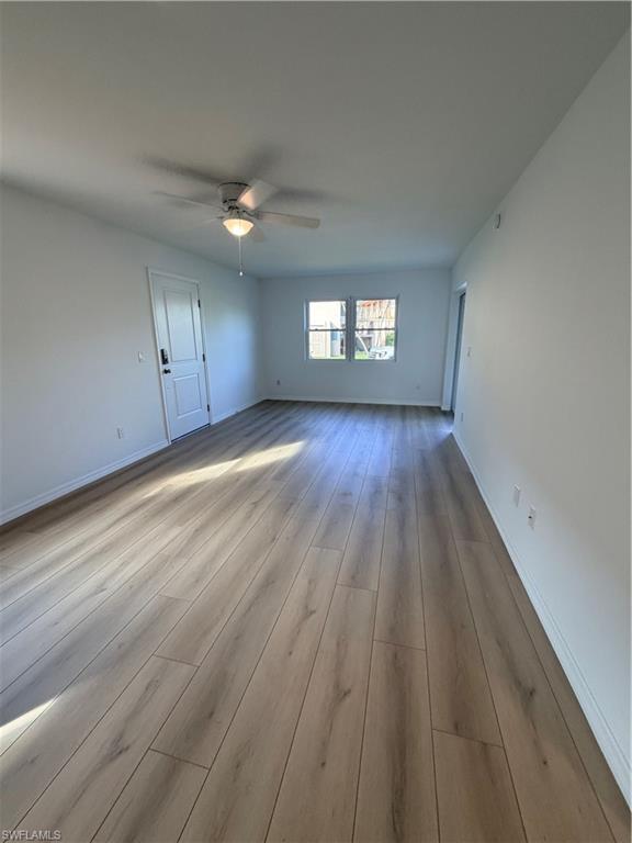 16881 Davis Road, Unit 312 Fort Myers, FL 33908 - Photo 2 of 7 Wood-finish flooring throughout, white walls, and a ceiling fan with light fixture