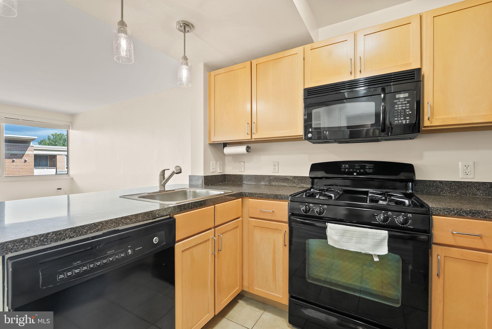 800 4th Street Southwest, Unit S513 Washington, DC 20024 - Photo 5 of 28 a kitchen with stainless steel appliances granite countertop a sink stove and microwave