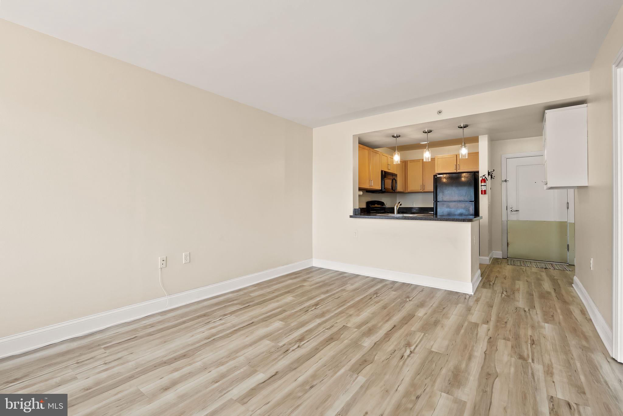 800 4th Street Southwest, Unit S513 Washington, DC 20024 - Photo 8 of 28 a view of a kitchen with wooden floor and a refrigerator