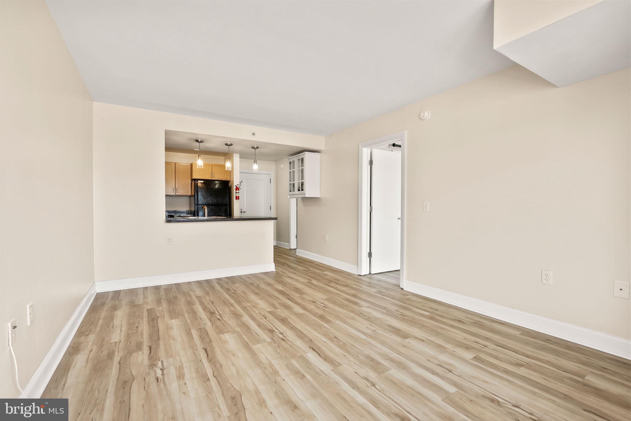 800 4th Street Southwest, Unit S513 Washington, DC 20024 - Photo 9 of 28 a view of a room with wooden floor and a kitchen