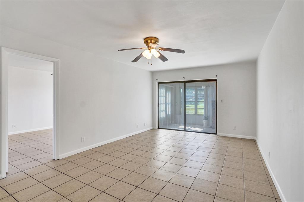 9273 Southwest 8th Street, Unit 117 Boca Raton, FL 33428 - Photo 12 of 40 a view of a room with a chandelier fan and windows