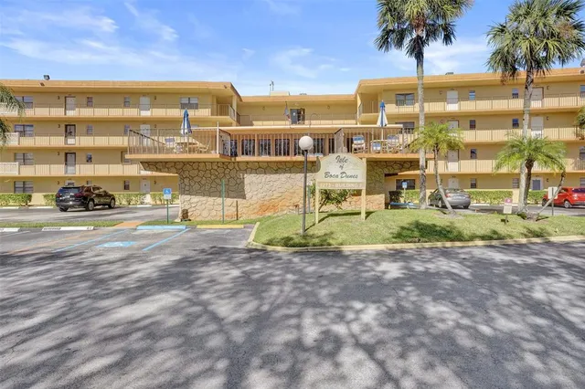 a front view of a house with a garden and lake view