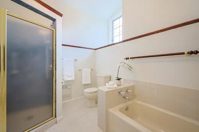 a bathroom with a bathtub a toilet and a shower