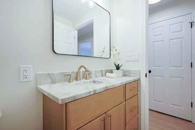 a bathroom with a granite countertop sink and a mirror