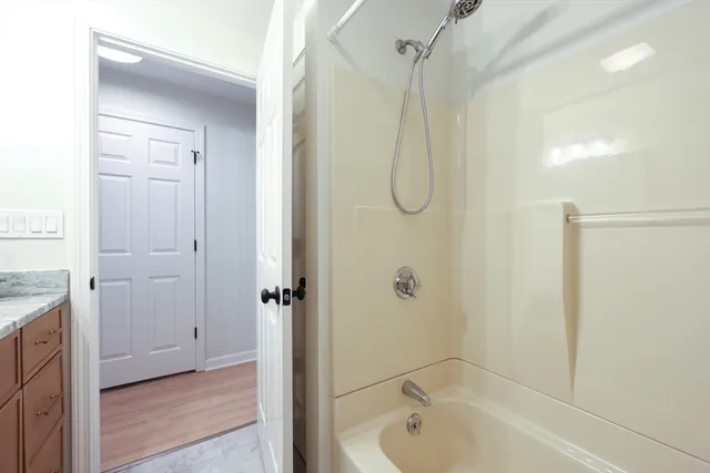 a bathroom with a shower a bath tub and a shower