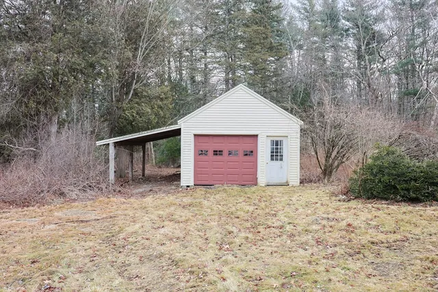 a view of a house with a yard and large tree