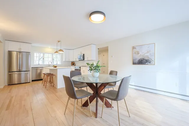 a view of a dining room with furniture and a refrigerator