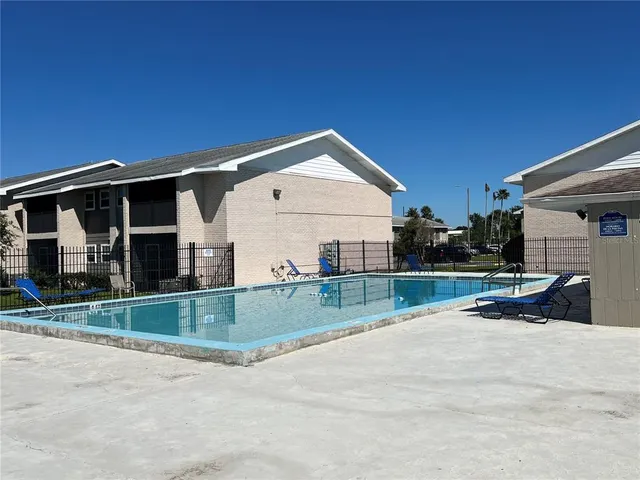 a view of a patio with a table and chairs under an umbrella