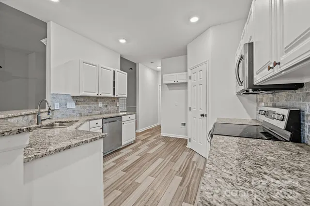 a kitchen with stainless steel appliances granite countertop a stove a sink and a refrigerator