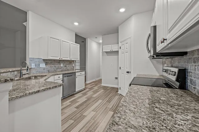 a kitchen with stainless steel appliances granite countertop a stove a sink and a refrigerator