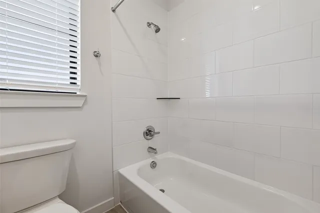 an empty room with windows and ceiling fan