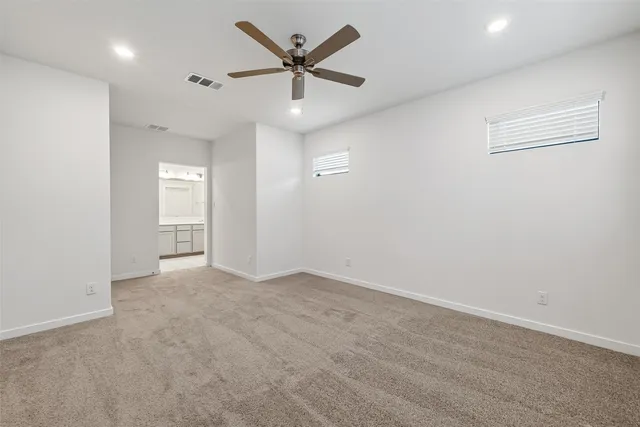 an empty room with window and ceiling fan