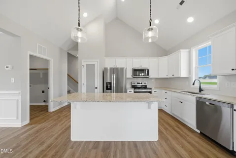 a large kitchen with stainless steel appliances kitchen island a large counter space a sink and cabinets