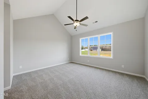 an empty room with windows and ceiling fan