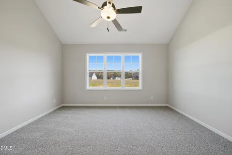 an empty room with a window and a ceiling fan