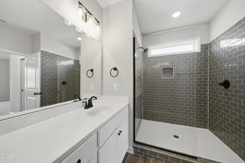 a bathroom with a shower sink and mirror