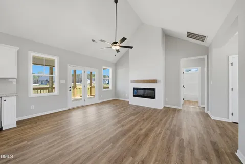 wooden floor fireplace and windows in an empty room