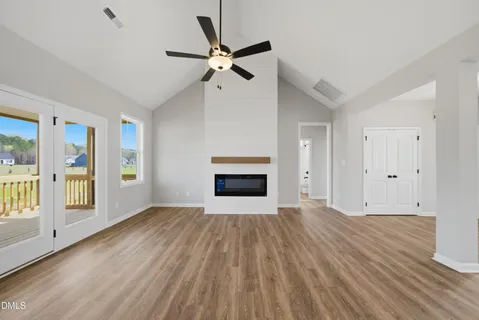 a view of empty room with wooden floor and fireplace