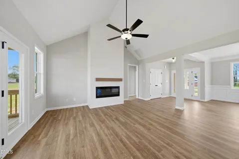 a view of empty room with wooden floor and fireplace