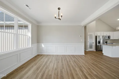 a view of empty room with wooden floor and window