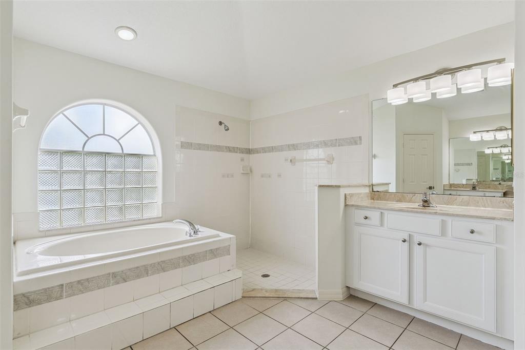 2440 Holly Ridge Court Clermont, FL 34711 - Photo 12 of 43 a spacious bathroom with a granite countertop sink a mirror and a bathtub